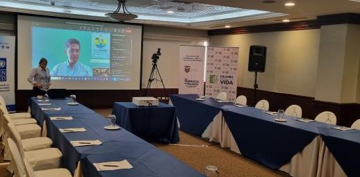 Sala de taller con mesas en U y pantalla