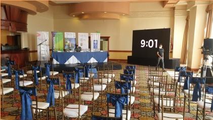 Salón preparado para un evento con sillas y pantalla